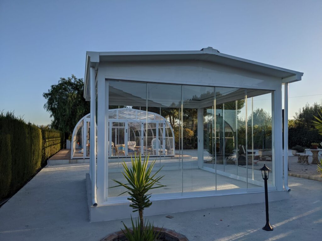 Pérgola con cerramiento de cortinas de cristal sin perfiles